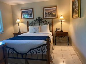 劳德代尔堡Casitas Coral Ridge的一间卧室配有一张床和两个带灯的床头柜