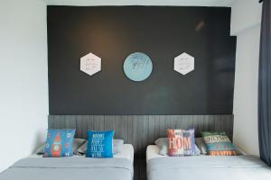 怡保米格利尔公寓式酒店的宿舍间的两张床,配有枕头和墙上的标志