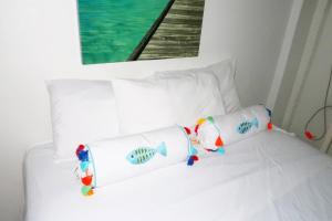 SavanetaApartment Brazil Beach Front Paradise的一张带两个枕头的白色床,上面有鱼