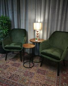 克里斯蒂娜港马瑞堡酒店的两把椅子和一张桌子,在房间里放着一盏灯