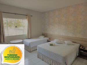 Lucas do Rio VerdeHotel Mandino的酒店客房设有两张床和窗户。