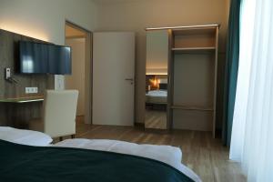 索尔陶Meyn's Apartments & Hotel的酒店客房设有一张床和一间带镜子的卧室