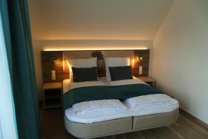 索尔陶Meyn's Apartments & Hotel的一间卧室配有一张带绿色和白色枕头的大床