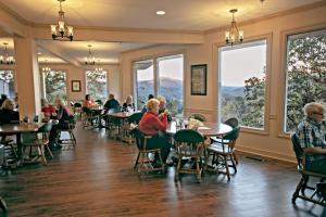 PinevillePine Mountain State Resort Park的坐在带大窗户的餐厅桌子上的人