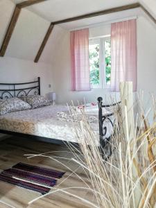 BoljevacRtanjski konak的一间卧室配有一张带粉红色窗帘的床