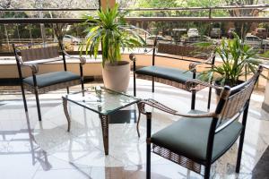 奥兰布拉Holambra Garden Hotel的庭院里摆放着一组椅子和一张玻璃桌