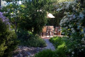 克莱尔Donnybrook Cottages - Hutt River的花园内摆放着桌椅和遮阳伞