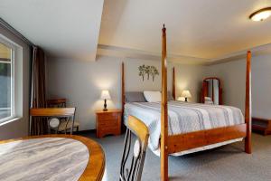本德Deschutes Riverside Escape的一间卧室设有四柱床和窗户。