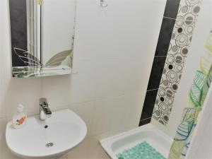 Yuzhnoukrainsk Beregynya的白色的浴室设有水槽和镜子