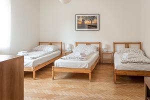 梅尔尼克Dobrý Kanec - Hostinec的配有白色墙壁和木地板的客房内的三张床