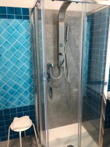 那不勒斯H Rooms boutique Hotel的浴室铺有蓝色瓷砖,设有淋浴。