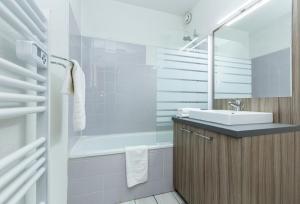 圣索林达尔沃Résidence Odalys L'Ouillon的浴室配有盥洗盆和浴缸。