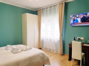 阿尔巴Villa Bellavista Alba, B&B的一间卧室配有一张床、一张书桌和一台电视。