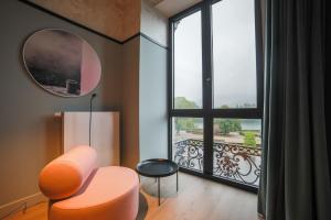 普罗丰德维耶Hôtel Vedette的客厅配有橙色椅子和大窗户