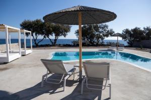 FoinikiáVilla Beltramo Santorini 2 bedroom private pool villa的游泳池旁的两把椅子和一把遮阳伞
