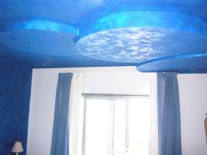 皮昂比诺La Rosa dei Venti Resort的一间拥有蓝色天花板和窗户的客房
