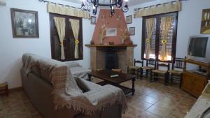 比利亚雷亚尔圣卡洛斯Casa Rural Al-Mofrag y Apartamentos El Mirador de Monfragüe的带沙发和壁炉的客厅
