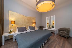 布拉格布拉格恩布里欧酒店的一间卧室配有一张带蓝色毯子的大床