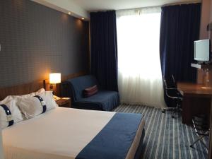 德里奥Holiday Inn Express Bilbao Airport, an IHG Hotel的酒店客房配有一张床、一把椅子和一张书桌