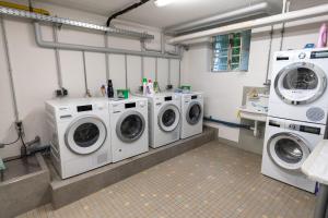 腓特烈港Stadthaus Seeblick G5 - Hostel的洗衣房配有3台洗衣机和水槽