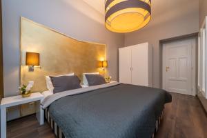 布拉格布拉格恩布里欧酒店的一间卧室配有一张带蓝色棉被的大床