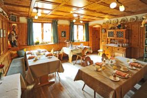 GroßheubachGasthaus Zur Krone的餐厅内带桌椅的用餐室