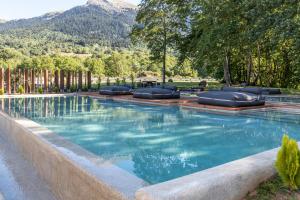 卡尔派尼西翁噢尼罗佩特拉精品酒店的一个带躺椅和山脉的游泳池