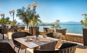 奈维斯Veya Hotel by Aminess的一间带桌椅和水的餐厅