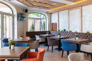 苏博蒂察Garni Hotel Royal Crown的餐厅设有木桌、椅子和窗户。
