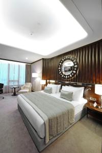 伯萨布尔萨会议温泉皇冠酒店 的一间卧室设有一张带木墙的大床