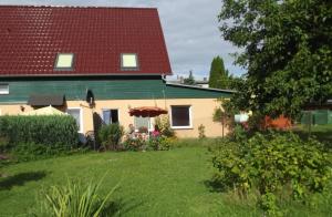 KachlinPension Lindenhof的一座红色屋顶的房子和一个院子