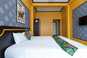 下龙湾VietHouse Homestay Ha Long的卧室设有一张白色大床和黄色的墙壁