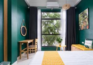 下龙湾VietHouse Homestay Ha Long的一间卧室配有一张床、一个窗口和一张书桌
