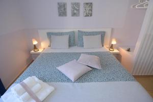 莱切B&B Lecce Stazione Centrale的一间卧室配有一张带两个枕头和两个灯的床。