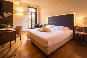 威尼托自由堡亚拉托瑞酒店的一间卧室配有一张大床、一张桌子和一张书桌