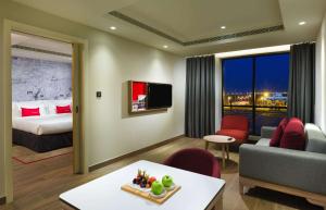 尼兹瓦IntercityHotel Nizwa的酒店客房设有一张特大号床和一间客厅。