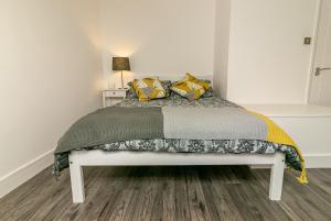 莱奇沃思Denby Lodge的一间卧室配有一张带黄色和绿色枕头的床