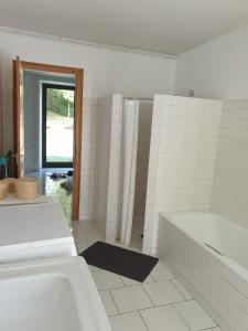 卢尔德La bergerie, maison spacieuse avec grand jardin, vue sur les Pyrénées的白色的浴室设有浴缸和淋浴。
