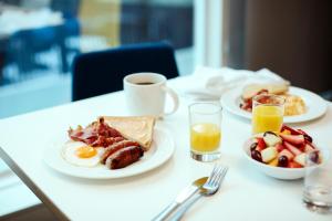 印第安纳波利斯印第安纳波利斯机场假日酒店的餐桌,包括两盘早餐食品和一杯咖啡