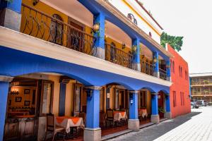 危地马拉埃斯帕诺拉别墅酒店的街道上带桌椅的蓝色建筑