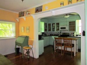 布鲁克斯维尔Ardendales的厨房设有黄色的墙壁和桌椅