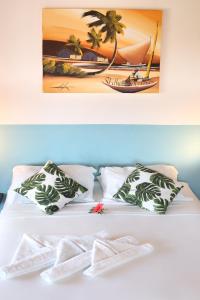 皮帕Pousada Aconchego da Pipa的一张带枕头的床和一张海滩景