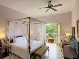 富国La Veranda Resort Phu Quoc - MGallery的一间卧室配有一张床和吊扇