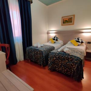 法瓦罗威尼托杜卡勒酒店的酒店客房,配有两张床和椅子