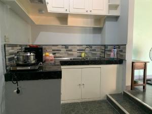 CandonBeinte Singko de Marso Apartments的厨房配有白色橱柜和水槽