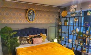 奥托佩尼Portobella Airport Aparthotel - Self Check in的一间卧室配有一张蓝色床头板的床
