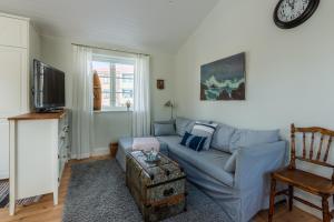 瓦克斯霍尔姆Small Red House In Central Vaxholm的客厅配有蓝色的沙发和电视