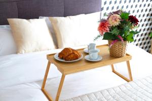迪沃讷莱班La Villa et sa plume的一张咖啡桌,床上摆放着羊角面包和一盘食物