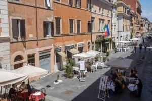罗马博格皮欧91号酒店的一群坐在街上桌子上的人,拿着雨伞