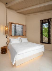 Kalpákion19.40 Luxury Guesthouse的卧室配有一张大白色床和窗户